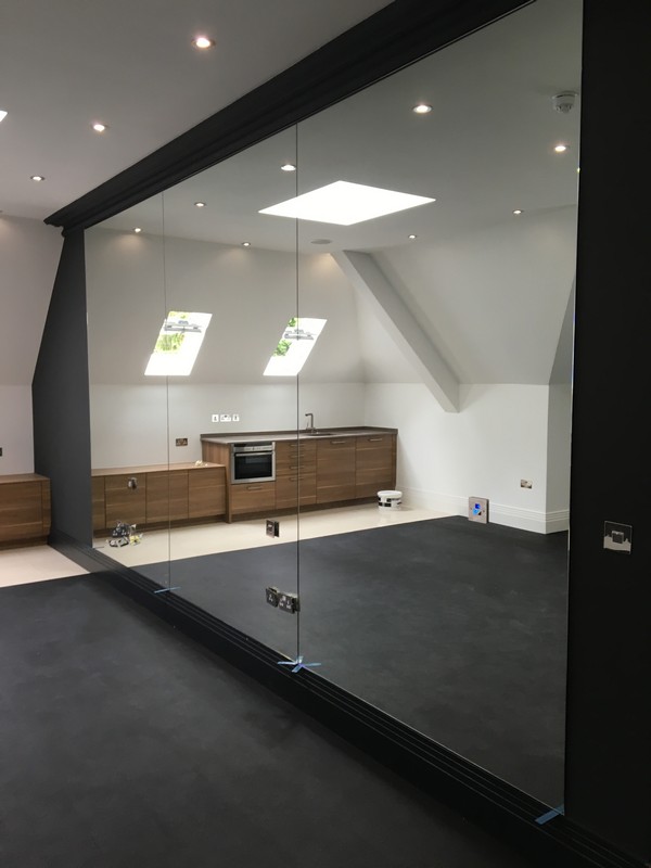 Frameless glass partition in loft conversion by Streatham glaziers