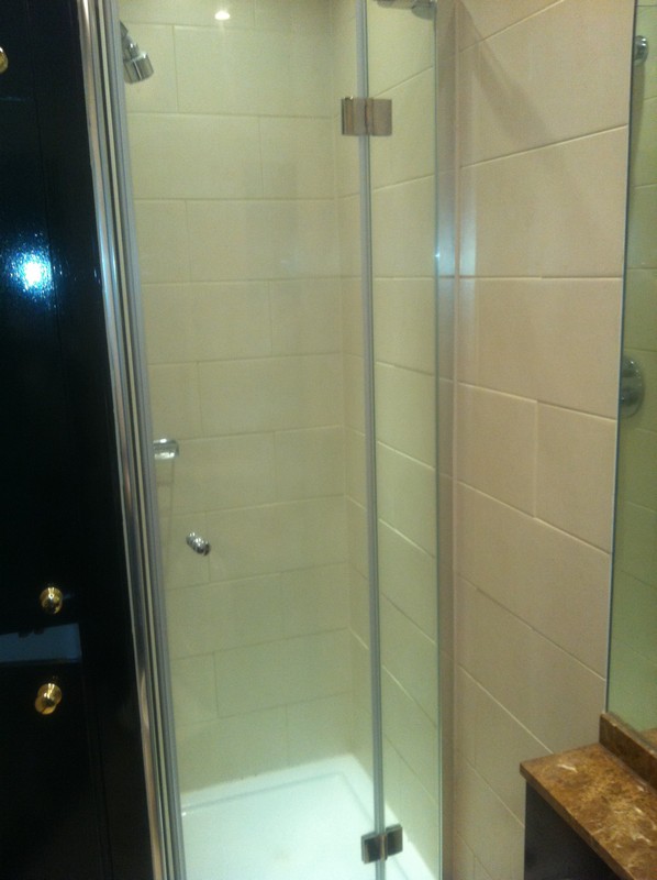 Frameless glass shower enclosure with chrome fittings in Streatham